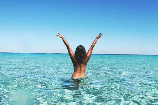 Woman waist deep in the ocean enjoying the beach